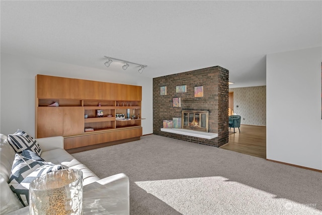 living room featuring a brick fireplace, carpet floors, and track lighting