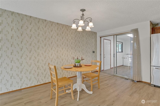 dining room with washer / dryer, a chandelier, a textured ceiling, and light hardwood / wood-style floors