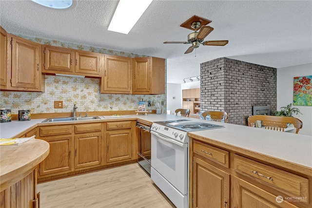 kitchen with dishwashing machine, sink, light hardwood / wood-style flooring, white range with electric stovetop, and a textured ceiling