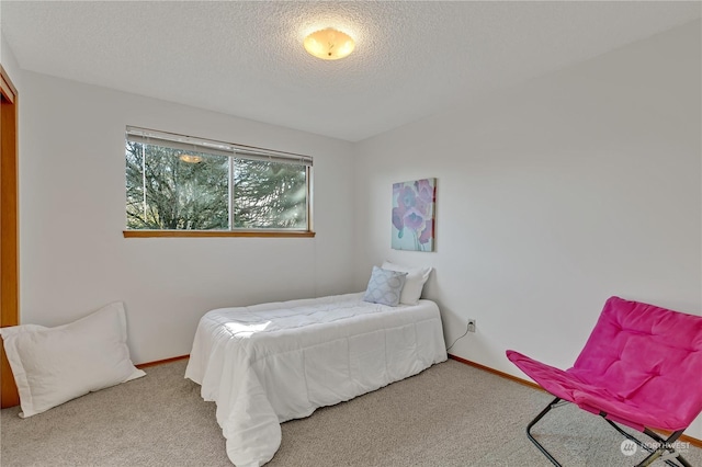 bedroom with a textured ceiling and carpet flooring