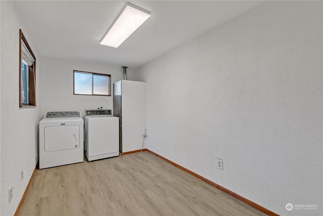 laundry room with independent washer and dryer and light wood-type flooring