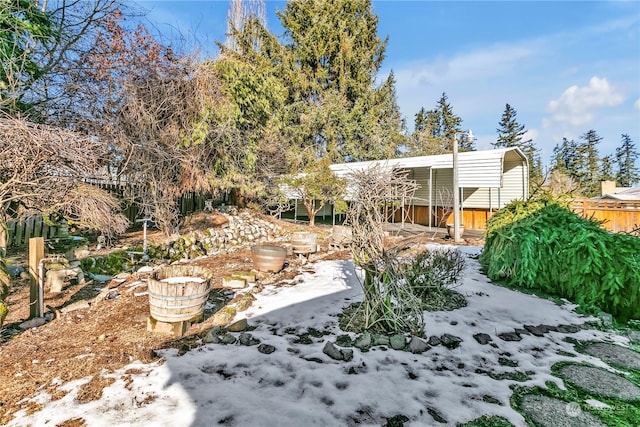 yard covered in snow with a carport