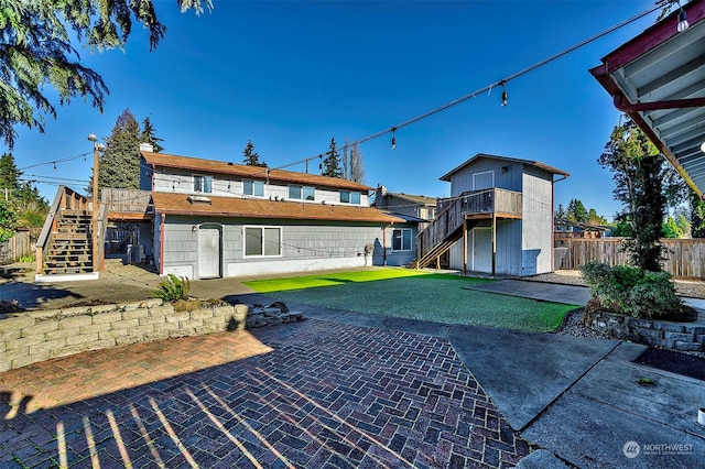 rear view of property with a patio and a lawn