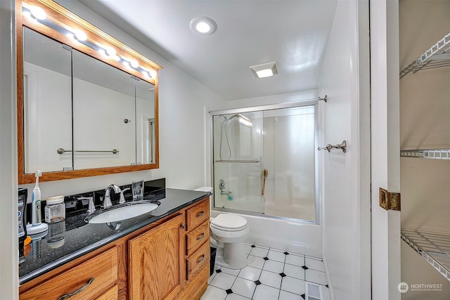 full bathroom featuring enclosed tub / shower combo, vanity, and toilet