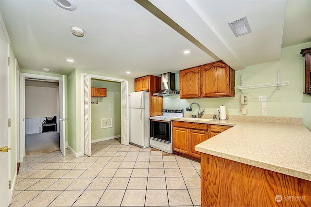 kitchen with white appliances, wall chimney exhaust hood, sink, and light tile patterned floors