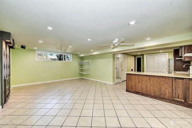 kitchen featuring light tile patterned floors, fridge, sink, and ceiling fan