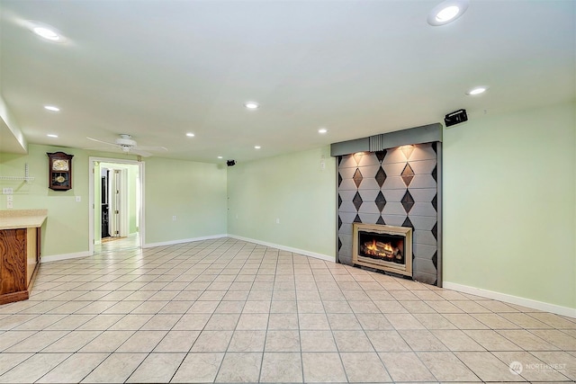 unfurnished living room featuring light tile patterned floors, a fireplace, and ceiling fan