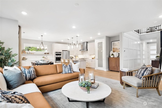 living room with a notable chandelier and light hardwood / wood-style flooring