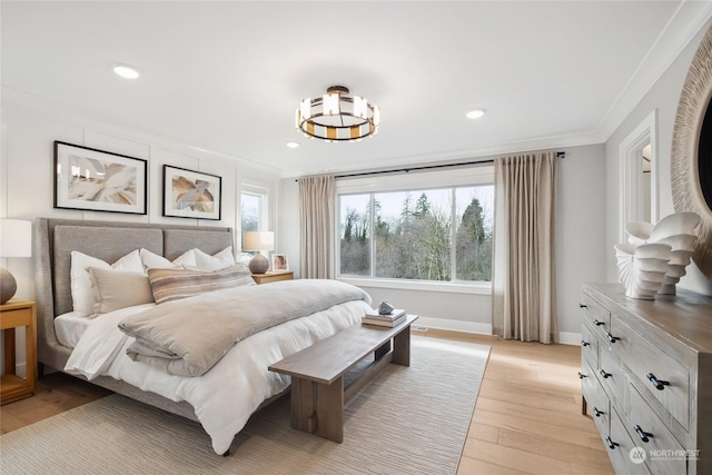 bedroom with ornamental molding and light hardwood / wood-style flooring