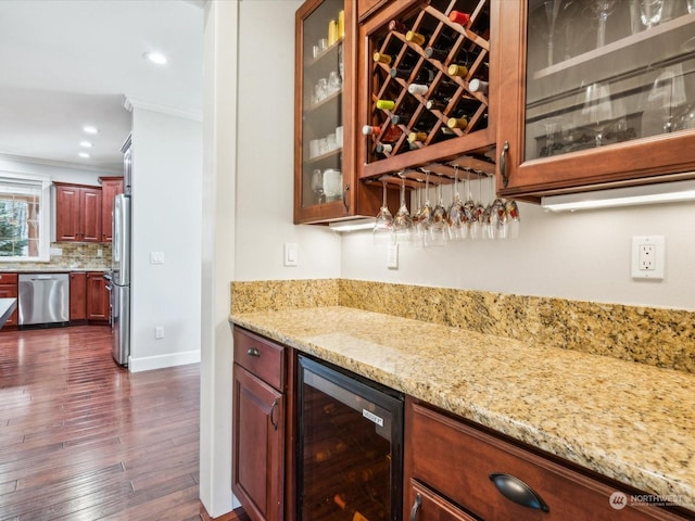 bar with beverage cooler, stainless steel appliances, dark wood-style floors, a bar, and tasteful backsplash