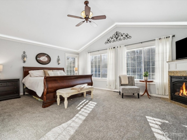 carpeted bedroom featuring a premium fireplace, baseboards, vaulted ceiling, and a ceiling fan