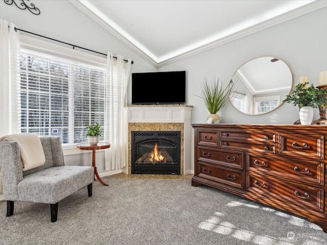 living area with ornamental molding, carpet flooring, vaulted ceiling, and a fireplace with flush hearth