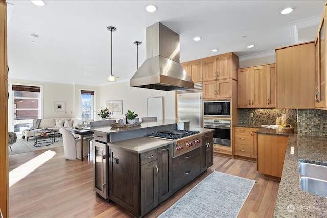 kitchen with island range hood, wine cooler, dark stone counters, hanging light fixtures, and built in appliances