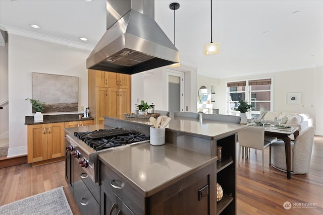 kitchen featuring crown molding, dark hardwood / wood-style floors, island range hood, stainless steel gas cooktop, and decorative light fixtures