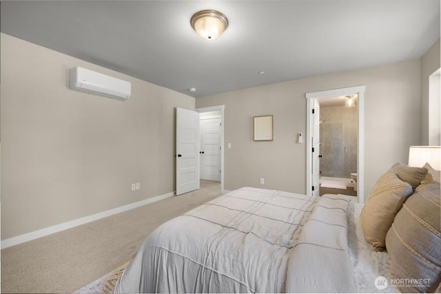 bedroom featuring baseboards, light carpet, ensuite bathroom, and a wall mounted air conditioner