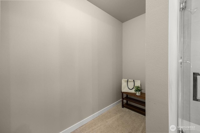 hall with baseboards, vaulted ceiling, and carpet