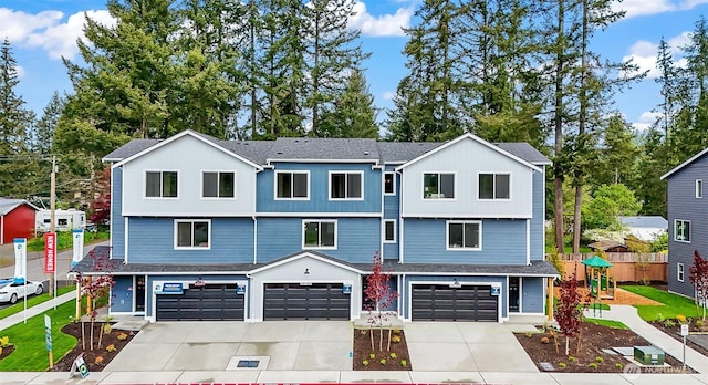 view of property featuring concrete driveway, an attached garage, and fence