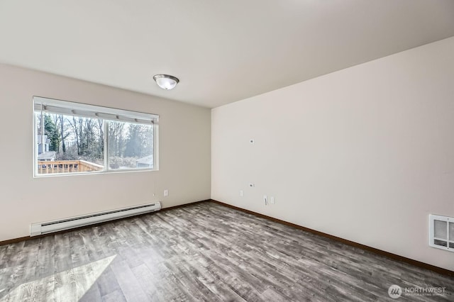 unfurnished room featuring baseboards, visible vents, a baseboard heating unit, and wood finished floors