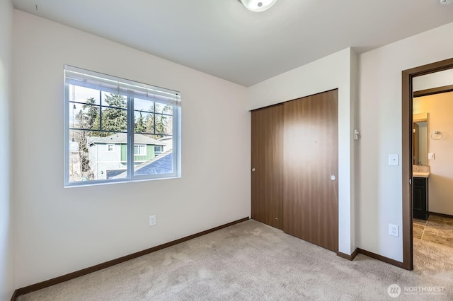 unfurnished bedroom featuring carpet floors, a closet, and baseboards