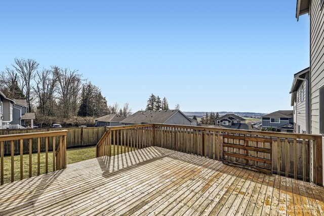 wooden terrace featuring a yard, a residential view, and fence