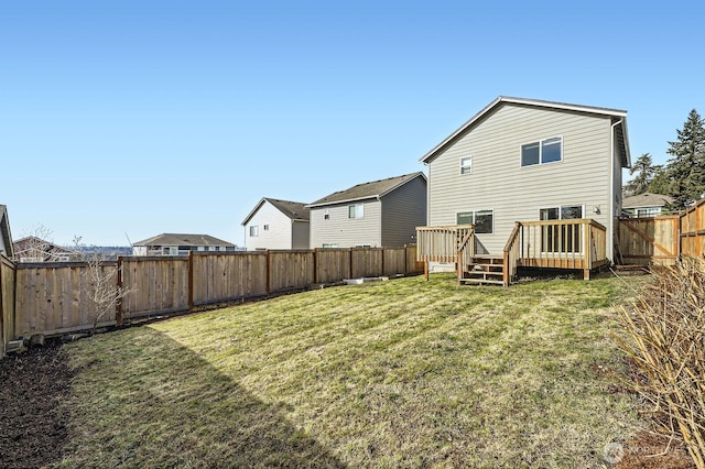 back of house featuring a deck, a yard, and a fenced backyard