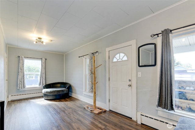 entryway with ornamental molding, baseboard heating, wood finished floors, and baseboards