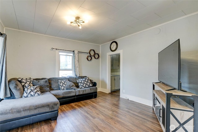 living area featuring ornamental molding, baseboards, and wood finished floors