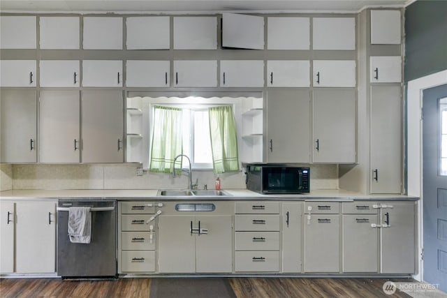 kitchen with open shelves, light countertops, stainless steel dishwasher, a sink, and black microwave