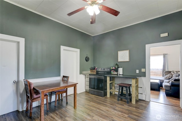 dining space with wood finished floors, a ceiling fan, and crown molding