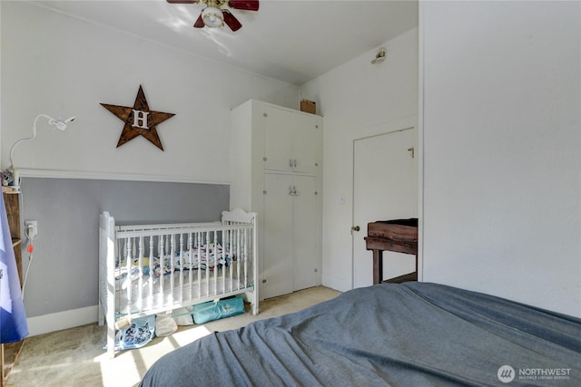 carpeted bedroom with a ceiling fan and baseboards