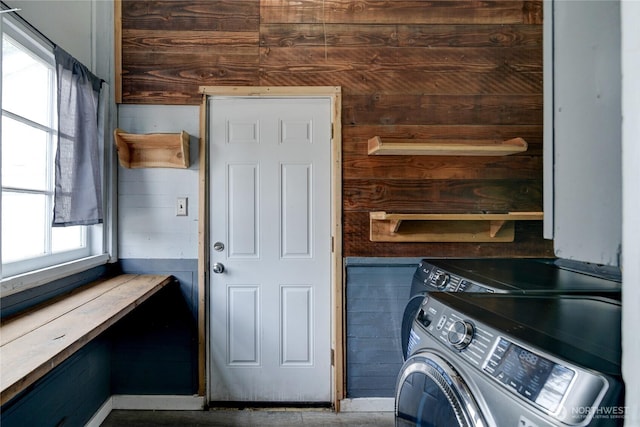 laundry area featuring washer and dryer, laundry area, and wooden walls