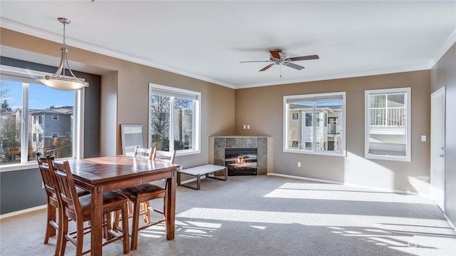 dining space featuring crown molding, light colored carpet, and a tile fireplace