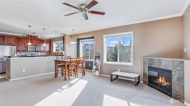 living room featuring light carpet, a fireplace, ornamental molding, and ceiling fan