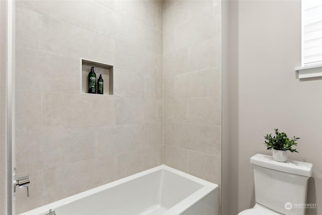 bathroom with toilet and tiled shower / bath combo