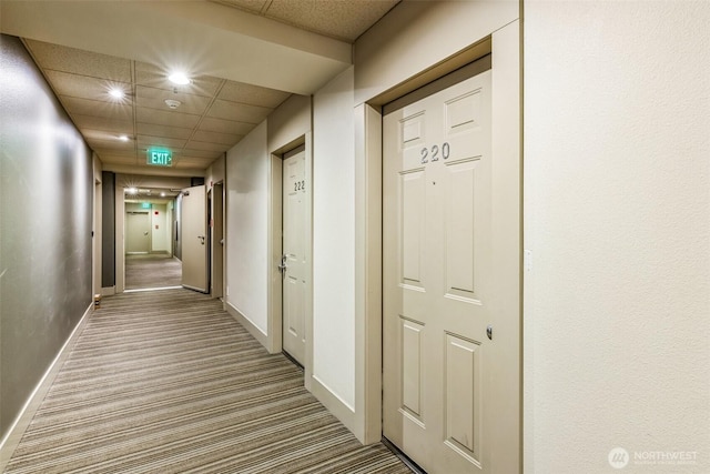 hallway with a paneled ceiling and carpet floors