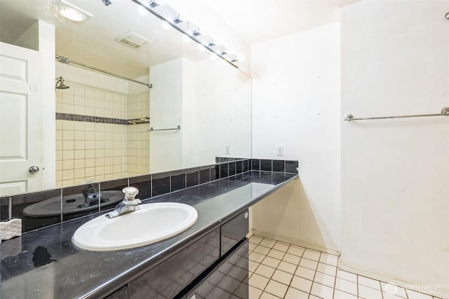 bathroom featuring tile patterned flooring, vanity, and walk in shower