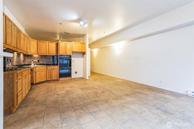 kitchen featuring tasteful backsplash, stainless steel dishwasher, sink, and double oven