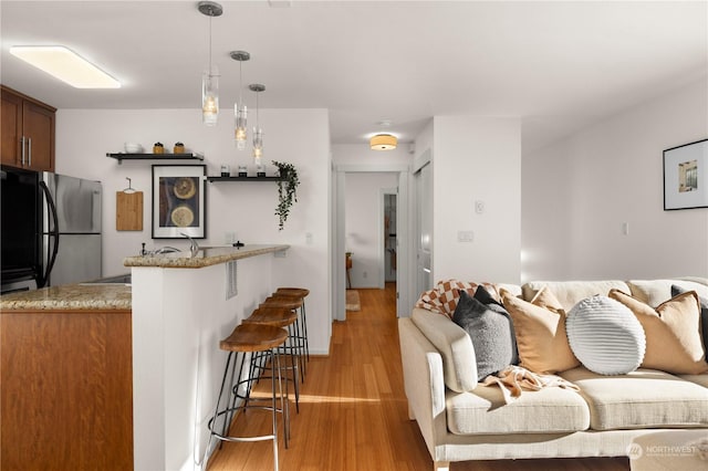 living room featuring light hardwood / wood-style flooring and bar area