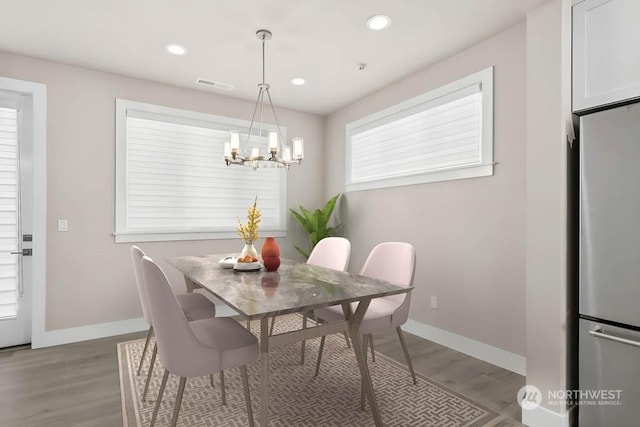 dining area with hardwood / wood-style flooring and a chandelier