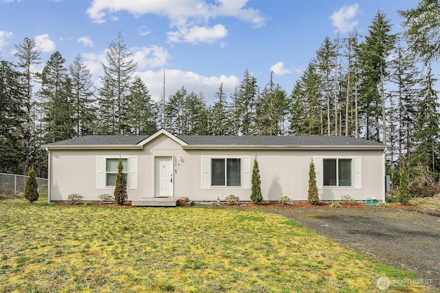 ranch-style home with a front yard and fence