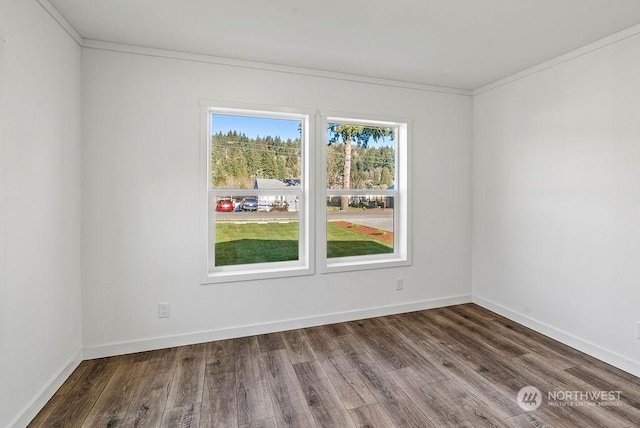 empty room with ornamental molding and dark hardwood / wood-style flooring