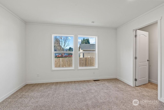 carpeted spare room featuring crown molding