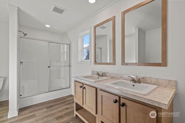 bathroom with crown molding, an enclosed shower, vanity, wood-type flooring, and toilet