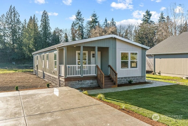 manufactured / mobile home featuring a porch and a front yard