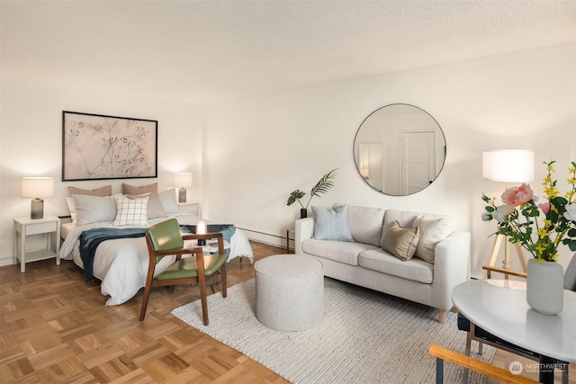 bedroom featuring parquet flooring, a baseboard heating unit, and a textured ceiling