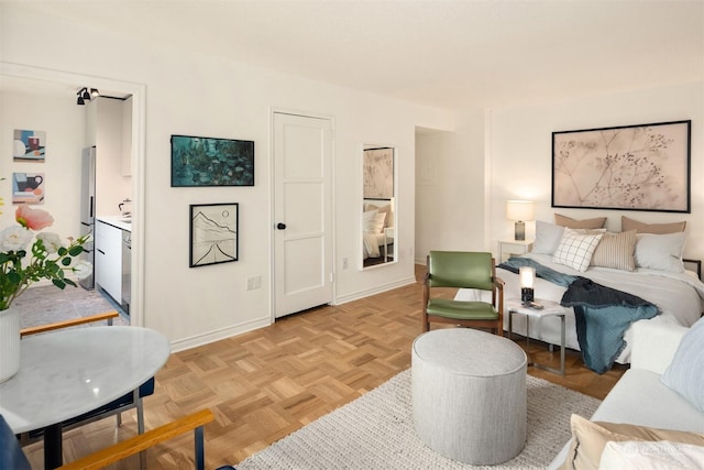 interior space with stainless steel refrigerator with ice dispenser, connected bathroom, and light parquet floors