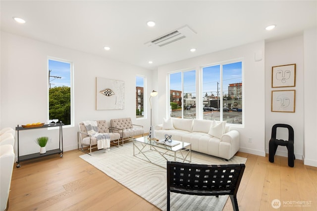 living area with light wood-style flooring, healthy amount of natural light, baseboards, and recessed lighting