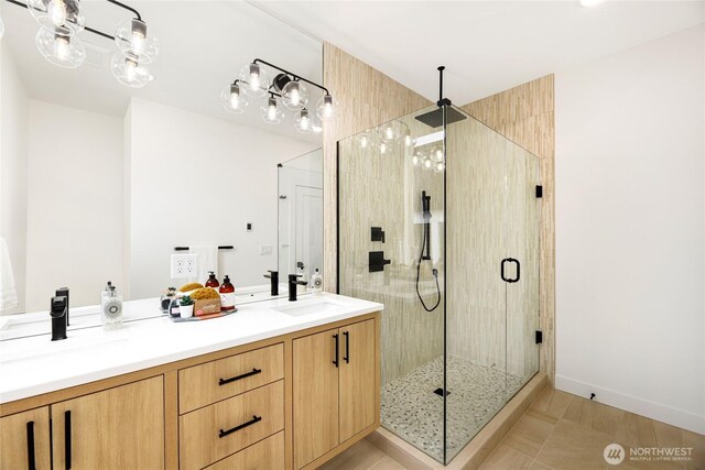bathroom featuring a stall shower and double vanity