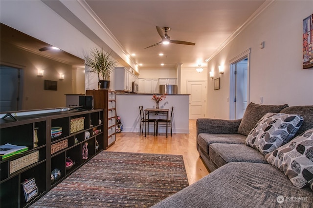 living room with crown molding, ceiling fan, and light wood-type flooring