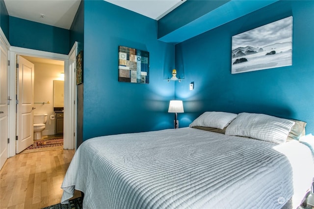 bedroom featuring light hardwood / wood-style flooring and ensuite bathroom